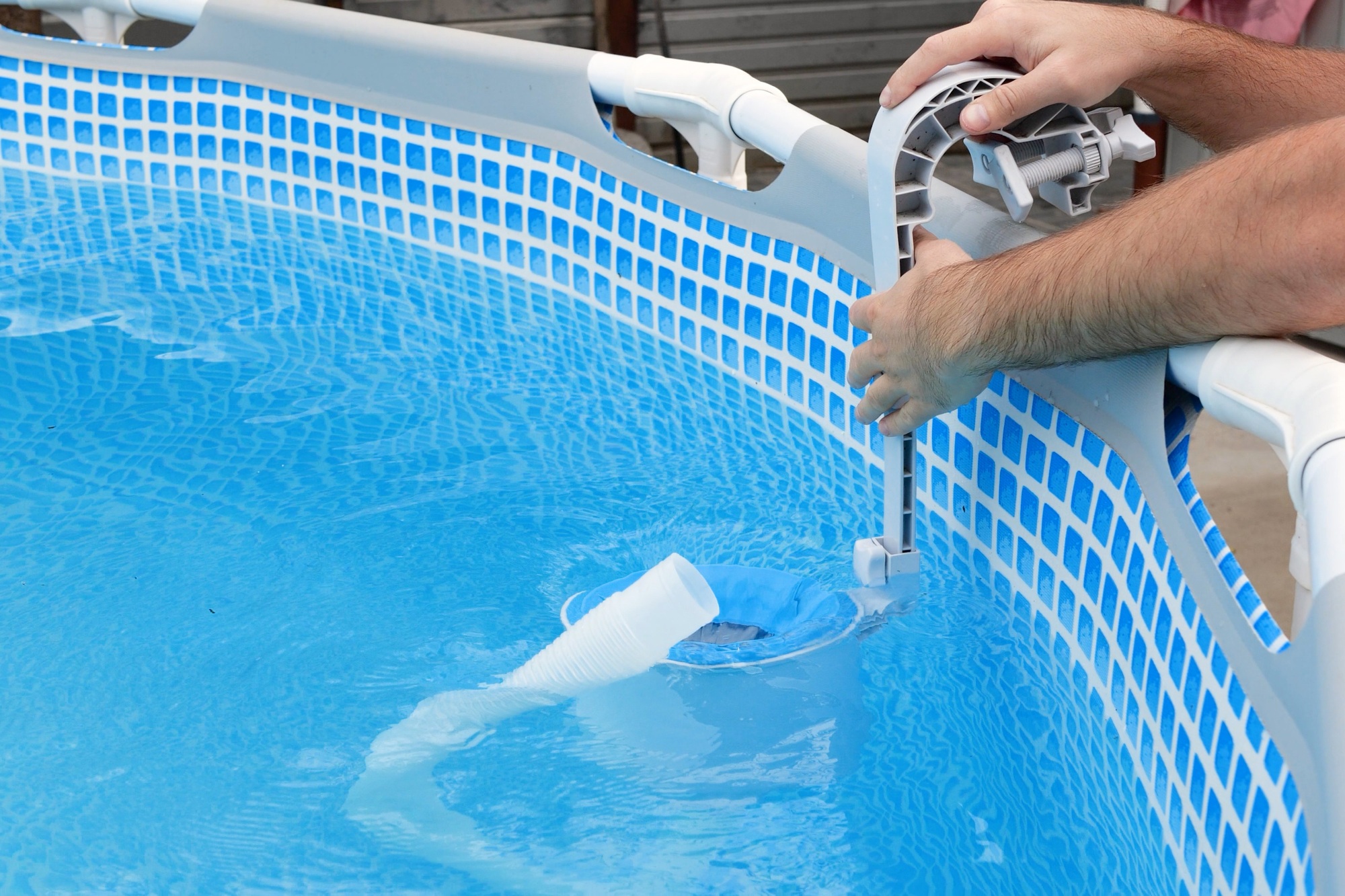 Man cleans skimmer for the frame pool. Contaminated pool cleaning concept